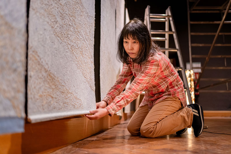 Kuenstlerin Mikako Suzuki bei der Vorbereitung der Wandtapeten mit filigranen Mustern aus Blattgold